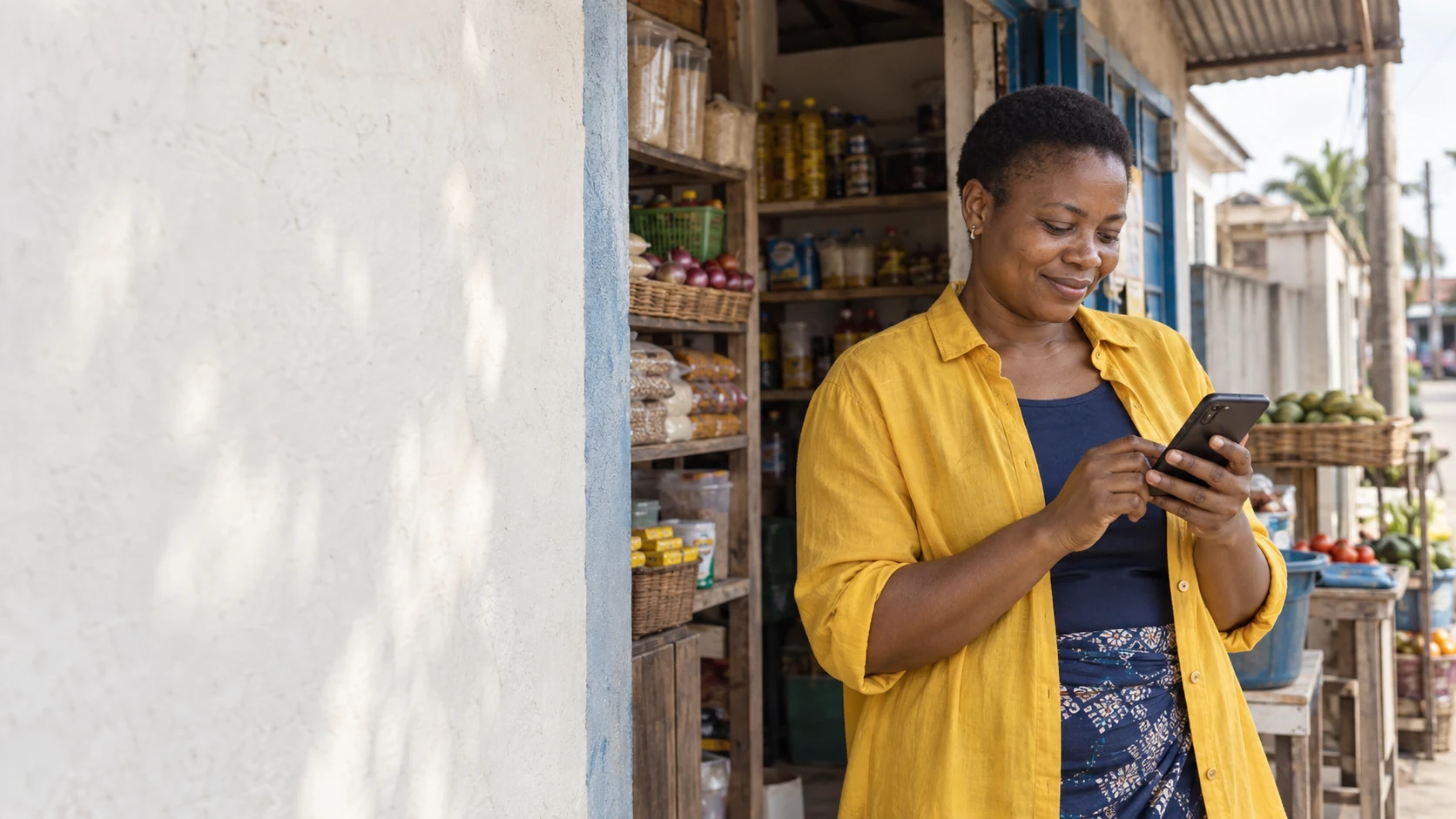 Nigerian shop owner using her phone at a neighbourhood store